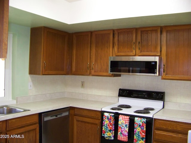 kitchen featuring light countertops, brown cabinetry, and appliances with stainless steel finishes