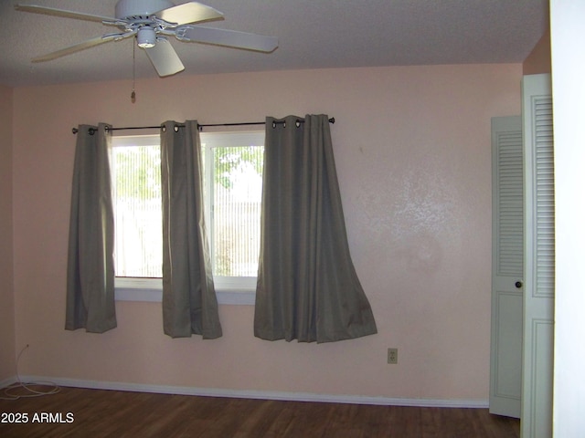 spare room with ceiling fan, baseboards, and wood finished floors