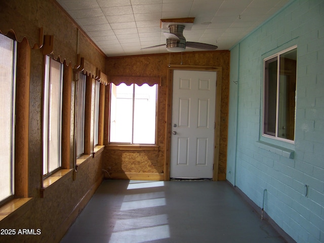 unfurnished sunroom with ceiling fan