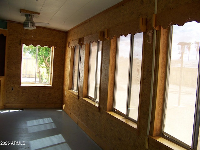 unfurnished sunroom featuring ceiling fan