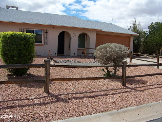 ranch-style home featuring fence, a garage, roof with shingles, and stucco siding