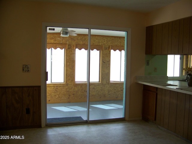 kitchen with a ceiling fan, light countertops, a healthy amount of sunlight, and brown cabinets