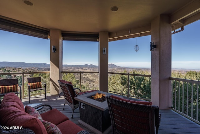 deck featuring a mountain view and an outdoor living space with a fire pit