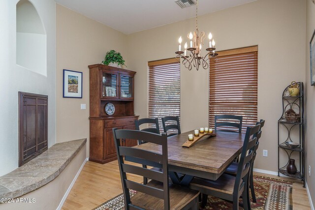 dining space with light wood-type flooring and an inviting chandelier