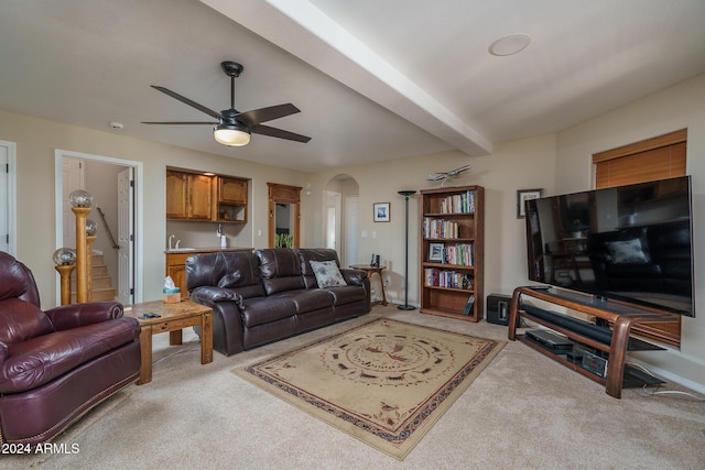 carpeted living room featuring beamed ceiling and ceiling fan