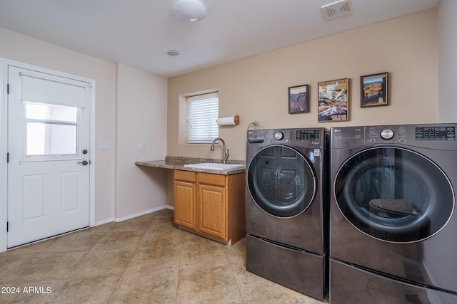 washroom with separate washer and dryer, sink, and cabinets