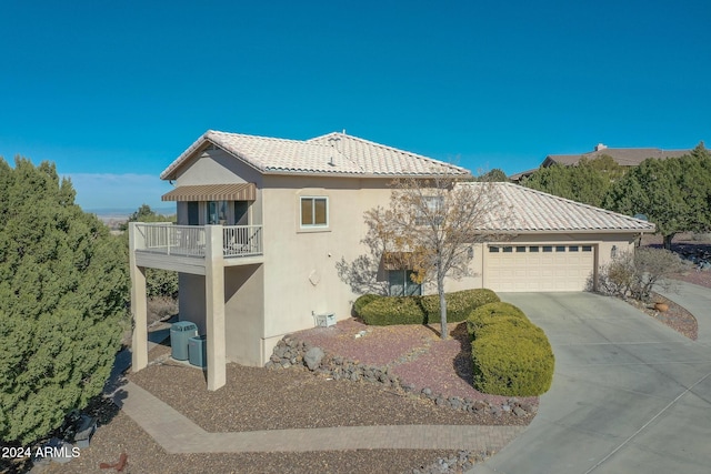 view of front of house featuring central AC, a balcony, and a garage