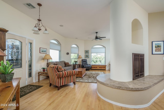 living room with light hardwood / wood-style floors and ceiling fan with notable chandelier