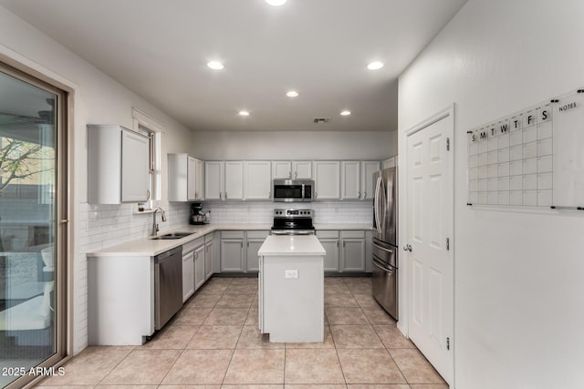 1647 W Gold Mine Way, San Tan Valley, AZ 85144 - kitchen with stainless steel appliances, a sink, a center island, decorative backsplash, and light countertops