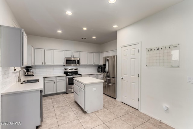 1647 W Gold Mine Way, San Tan Valley, AZ 85144 - kitchen with appliances with stainless steel finishes, a sink, decorative backsplash, a center island, and light tile patterned flooring