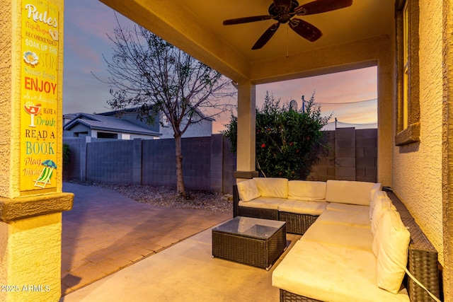 1647 W Gold Mine Way, San Tan Valley, AZ 85144 - patio terrace at dusk with a fenced backyard, a ceiling fan, and an outdoor living space
