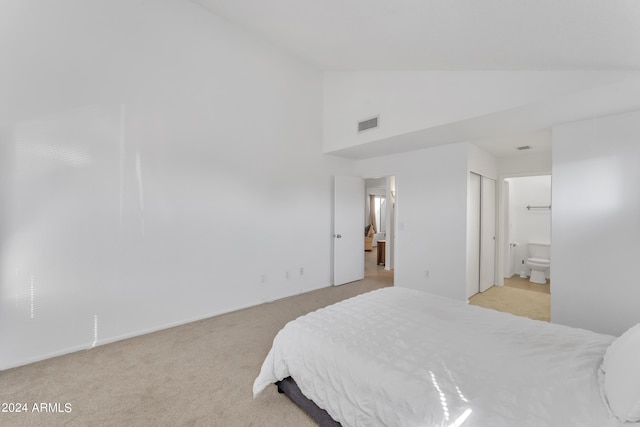 carpeted bedroom with connected bathroom and high vaulted ceiling