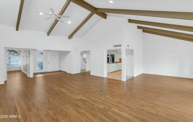 unfurnished living room with beam ceiling, light hardwood / wood-style flooring, high vaulted ceiling, and ceiling fan