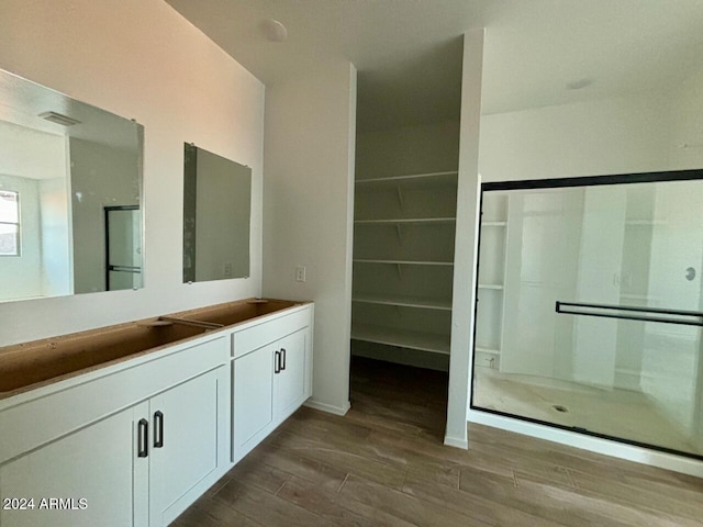 bathroom featuring hardwood / wood-style floors, vanity, and a shower with shower door