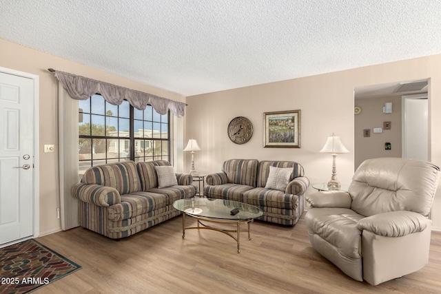 living room featuring a textured ceiling and light wood-type flooring