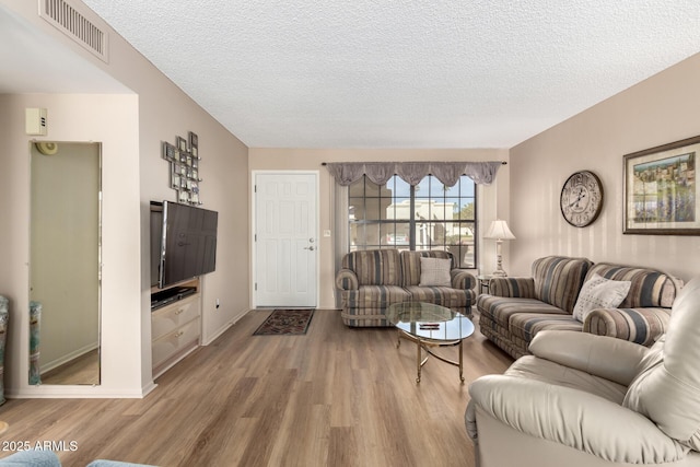 living room featuring a textured ceiling and light hardwood / wood-style flooring