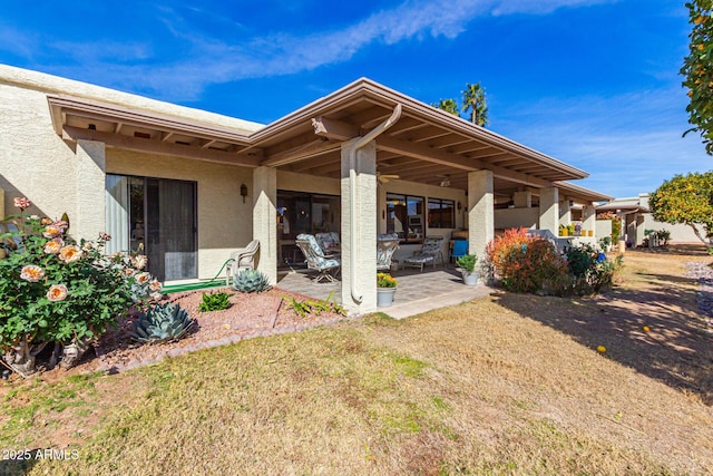 back of house with a lawn and a patio