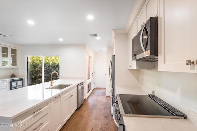 4525 N 66th St Unit 95, Scottsdale, AZ 85251 - kitchen with a sink, appliances with stainless steel finishes, beverage cooler, recessed lighting, and light stone counters