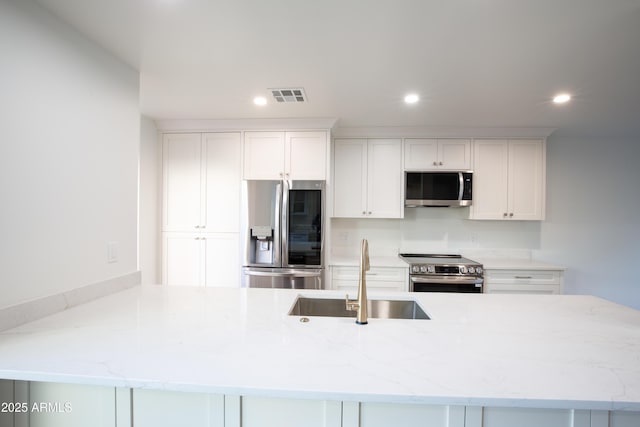 4525 N 66th St Unit 95, Scottsdale, AZ 85251 - kitchen featuring appliances with stainless steel finishes, a sink, white cabinets, recessed lighting, and light stone countertops