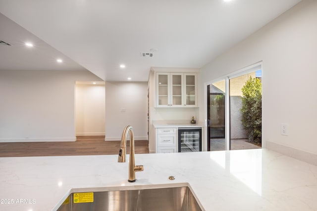 4525 N 66th St Unit 95, Scottsdale, AZ 85251 - kitchen with beverage cooler, a sink, recessed lighting, glass insert cabinets, and white cabinetry