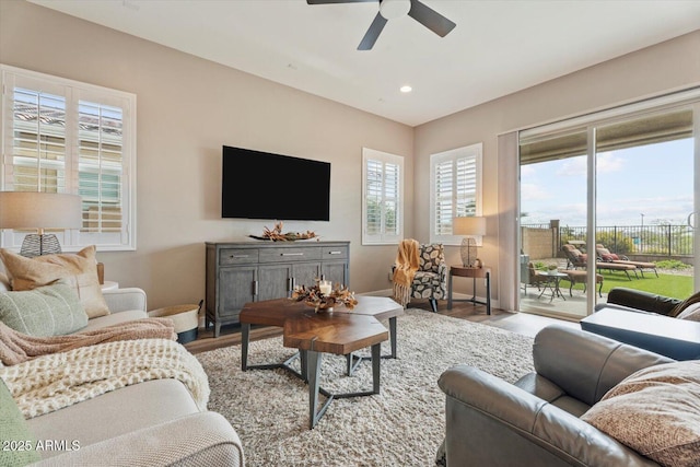 living area with a ceiling fan, recessed lighting, wood finished floors, and baseboards