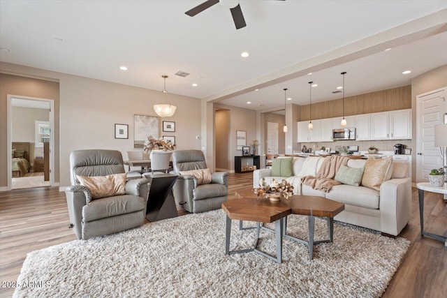 living area featuring visible vents, recessed lighting, a ceiling fan, and light wood-style floors