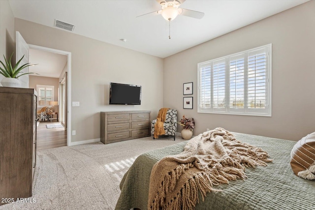 carpeted bedroom featuring baseboards, visible vents, and ceiling fan