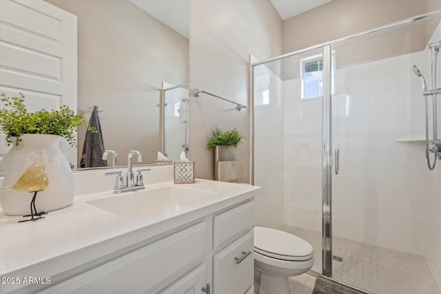 bathroom featuring vanity, a shower stall, and toilet