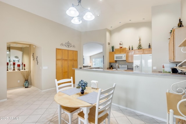 dining room featuring lofted ceiling, arched walkways, an inviting chandelier, light tile patterned floors, and baseboards