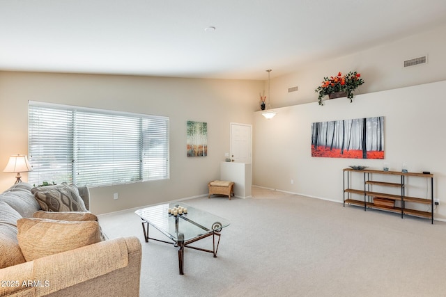 living area featuring visible vents, light carpet, baseboards, and vaulted ceiling