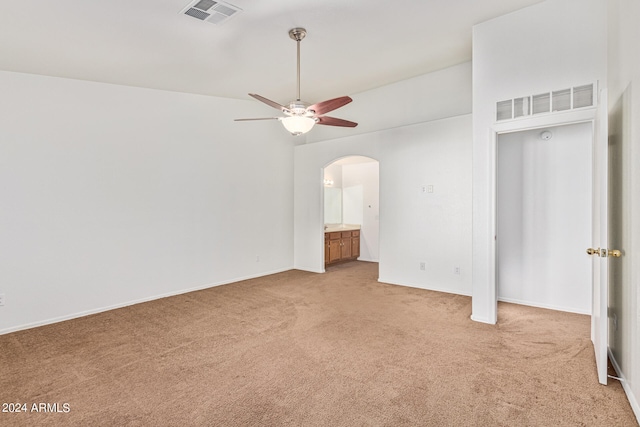 interior space with ceiling fan, ensuite bathroom, carpet, and a towering ceiling