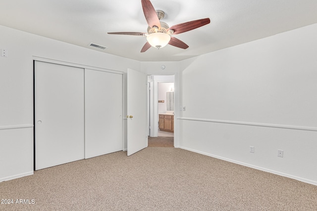 unfurnished bedroom with ceiling fan, light colored carpet, and a closet