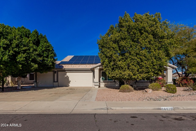 view of front of home featuring solar panels and a garage