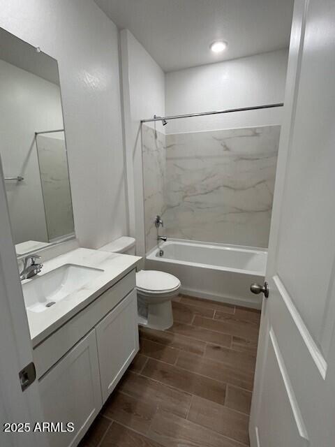 full bathroom with vanity, tiled shower / bath combo, and toilet