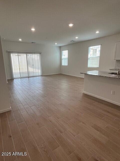 unfurnished room featuring wood-type flooring and a wealth of natural light