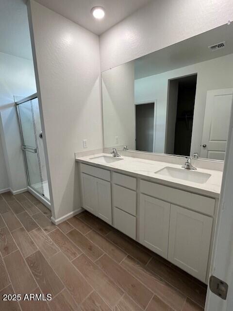 bathroom featuring vanity and an enclosed shower