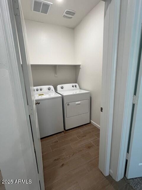 laundry area featuring separate washer and dryer and wood-type flooring