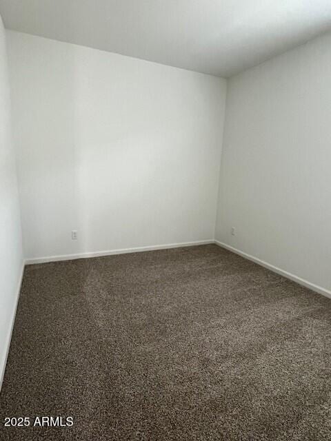 unfurnished room with dark colored carpet