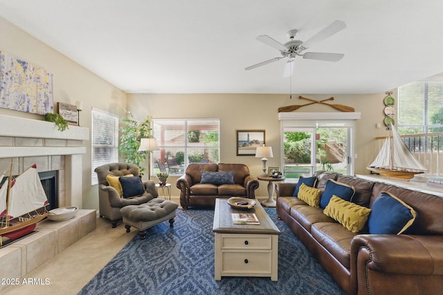 carpeted living room with ceiling fan and a fireplace