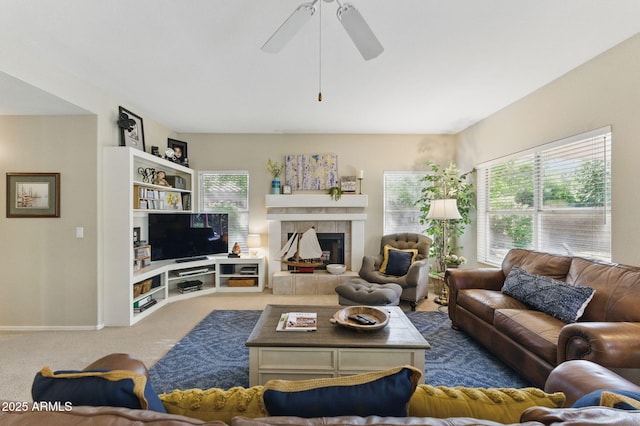 carpeted living room with a ceiling fan and a fireplace