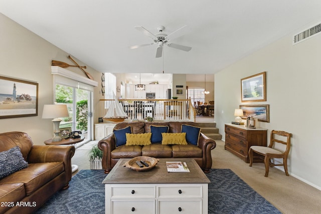 living area featuring carpet floors, ceiling fan, baseboards, and visible vents