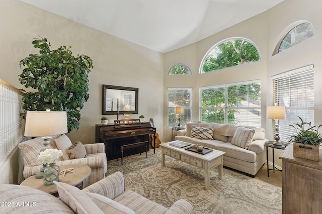living room with plenty of natural light and high vaulted ceiling