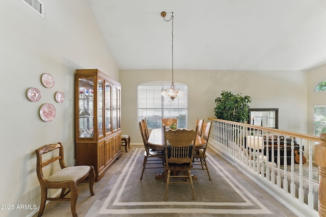 dining room with an inviting chandelier, visible vents, vaulted ceiling, and a wealth of natural light