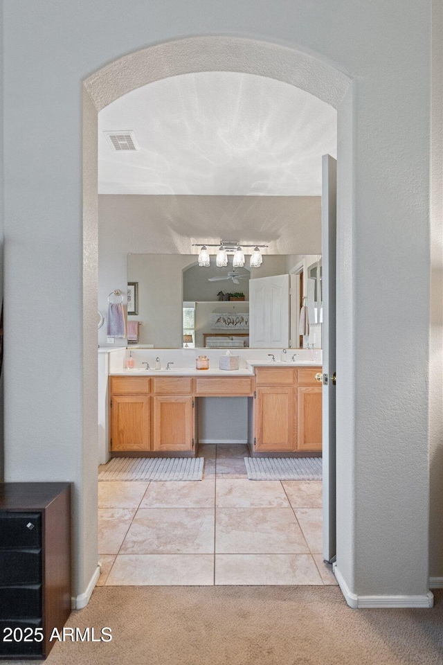 bathroom featuring double vanity, visible vents, a sink, and tile patterned flooring
