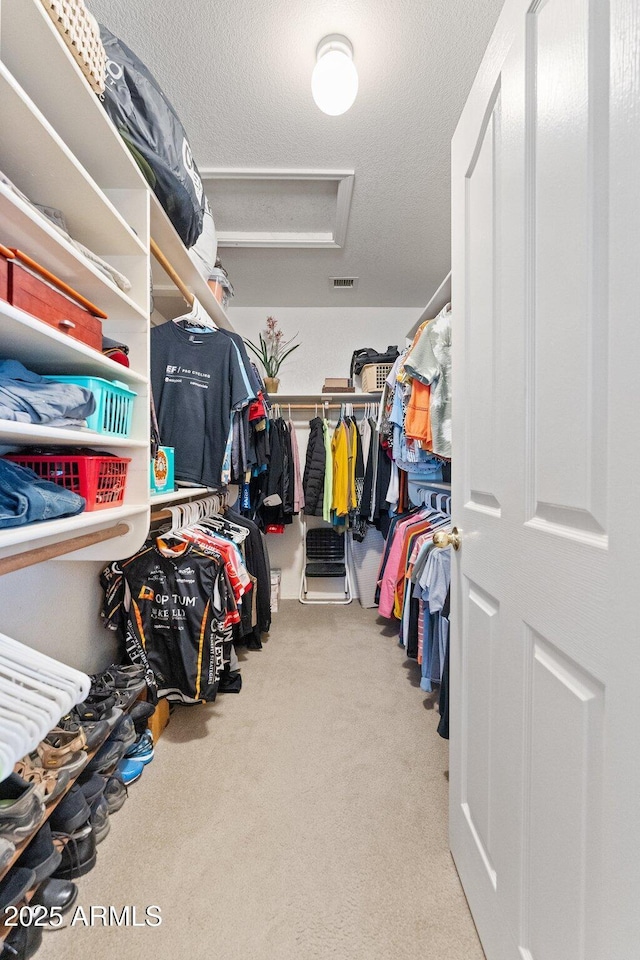 spacious closet with carpet floors and attic access