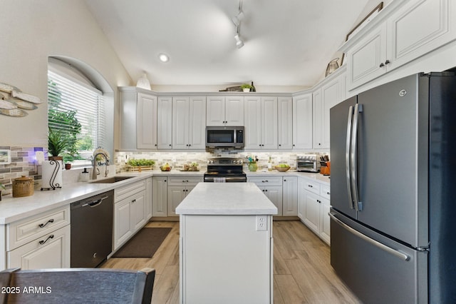 kitchen featuring a center island, a sink, decorative backsplash, and stainless steel appliances