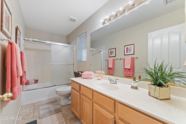 bathroom with vanity, toilet, tile patterned floors, combined bath / shower with glass door, and visible vents
