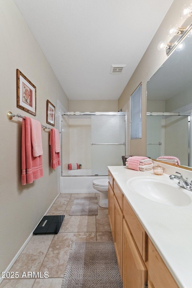 full bath with visible vents, vanity, baseboards, toilet, and shower / bath combination with glass door