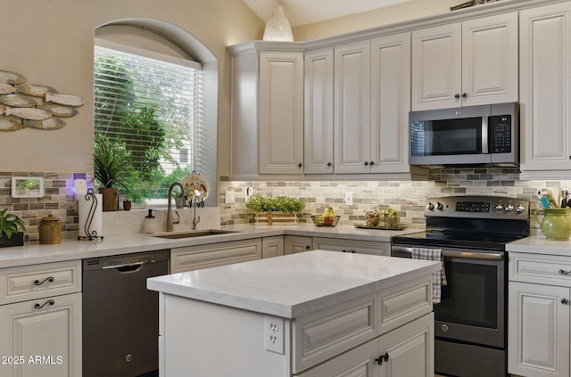 kitchen featuring decorative backsplash, appliances with stainless steel finishes, a healthy amount of sunlight, and a sink