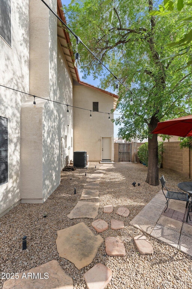 view of patio / terrace with fence, a gate, and central air condition unit